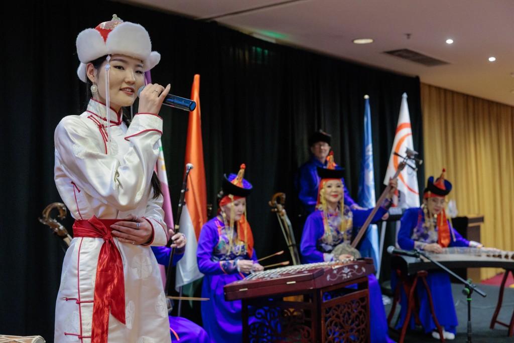 Cultural performance on stage with traditional music and international flags